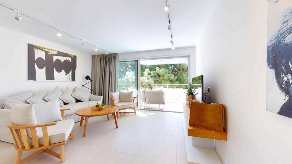 Appartement en gros œuvre avec vue depuis le séjour sur la grande fenêtre et la sortie vers le balcon.