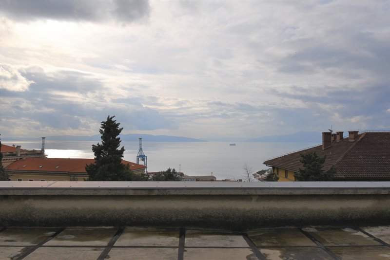 Toit-terrasse avec vue au-dessus des toits en tuiles sur le port