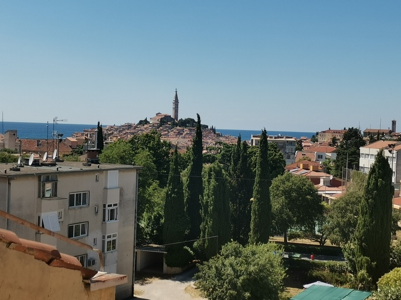 Vue sur la vieille ville avec clocher par-dessus les cyprès