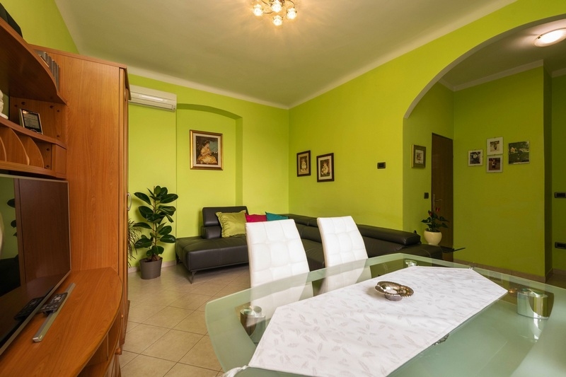 Salon avec mur vert et coin salon blanc à Rovinj