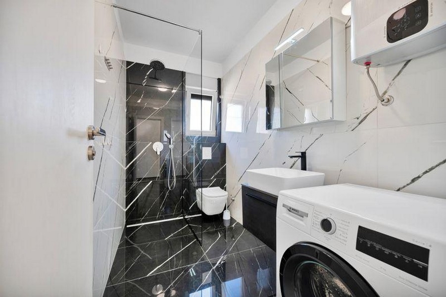 Salle de bains avec douche et lave-linge