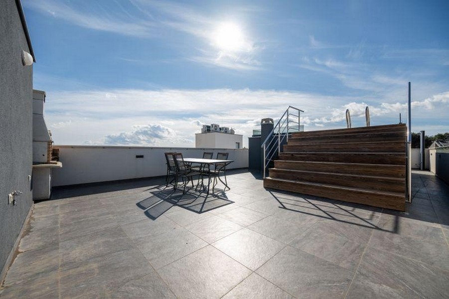 Grand toit-terrasse avec coin salon et terrasse en bois