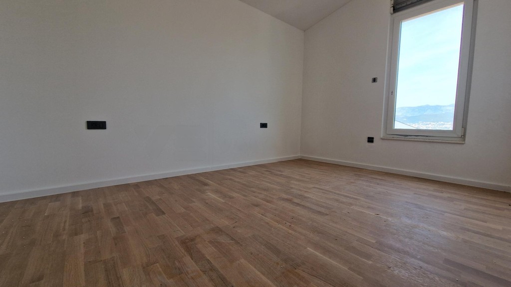Pièce vide avec parquet et fenêtre donnant sur les montagnes