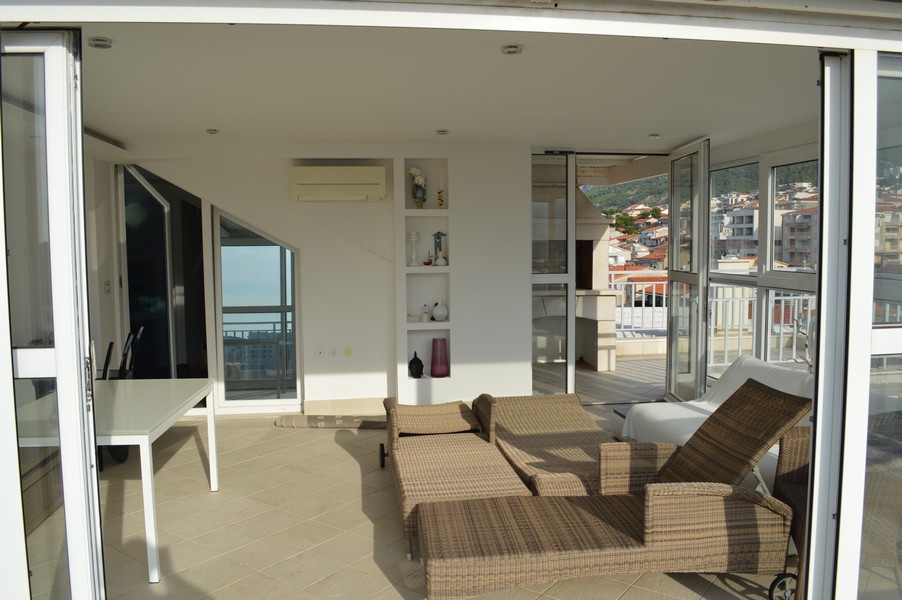 Façade vitrée ouverte avec bains de soleil et niche à étagères derrière