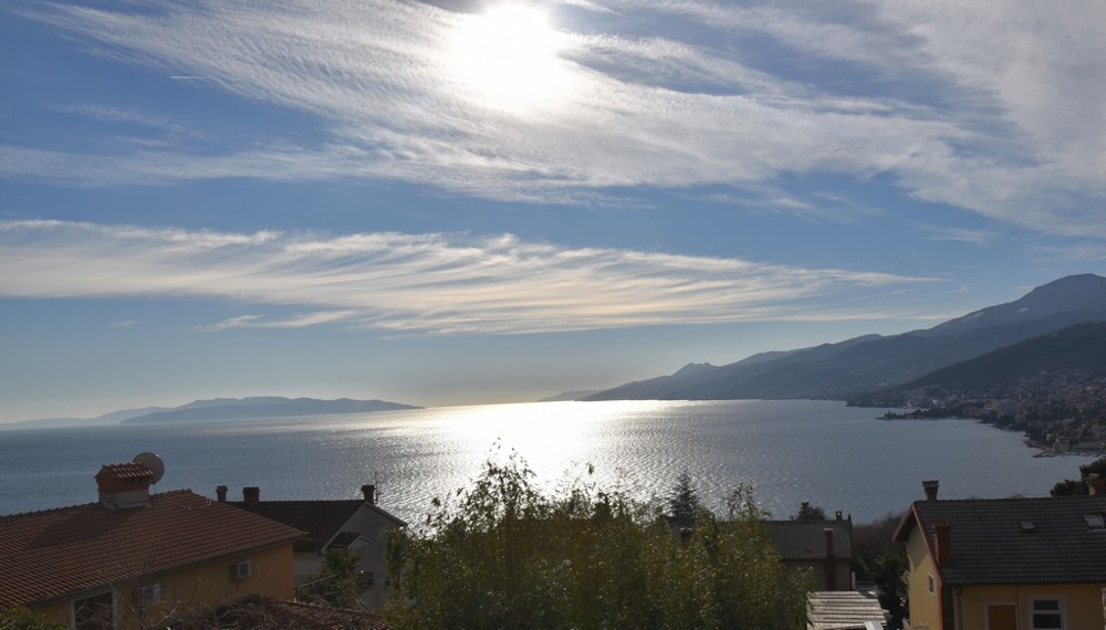 Contre-jour sur la baie derrière les toits en tuiles