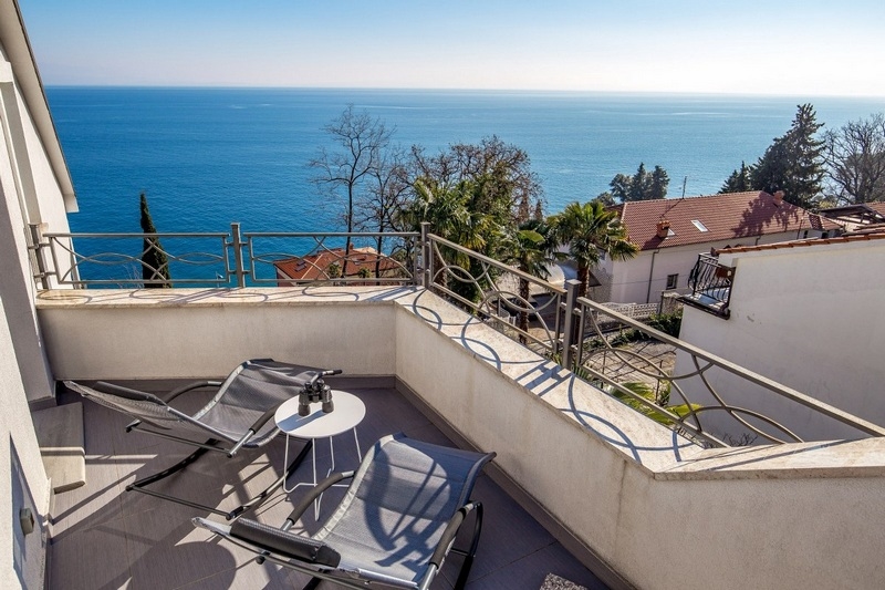Balcon avec deux chaises longues au-dessus de la pleine mer