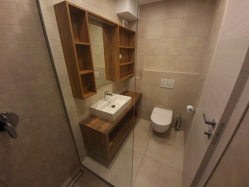 Salle de bains avec meuble-lavabo en bois et niches de rangement ouvertes