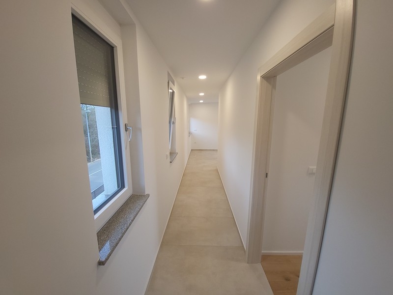 Couloir lumineux avec niche de fenêtre et porte de pièce ouverte