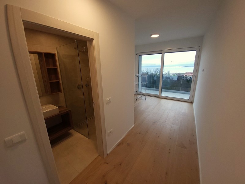 Pièce avec parquet et douche ouverte dans la pièce voisine