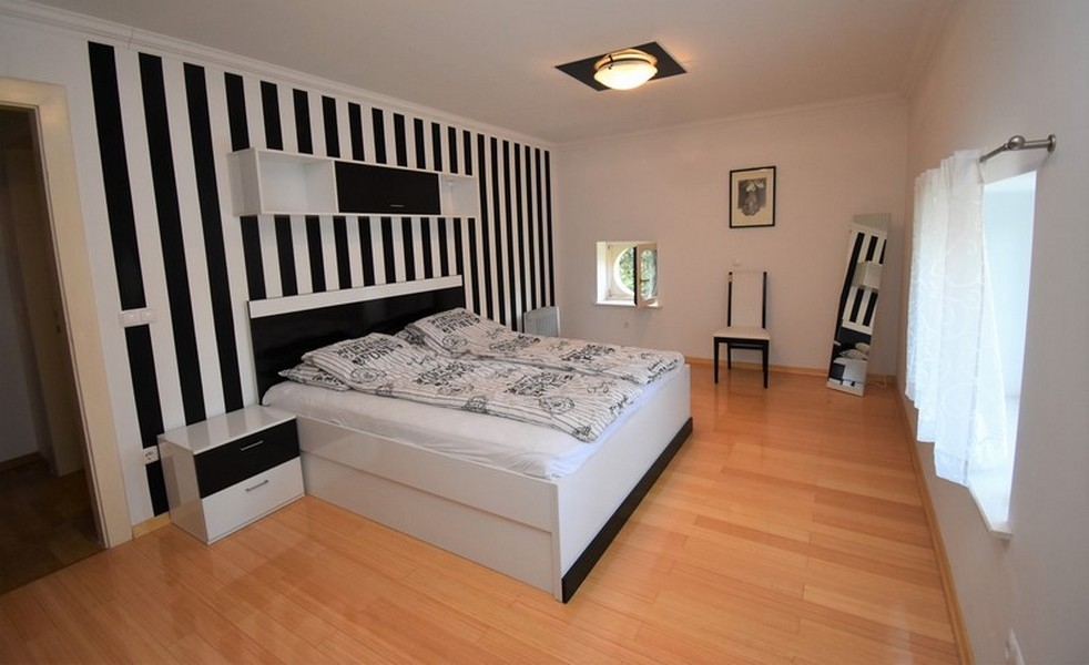 Chambre avec lit double et mur rayé