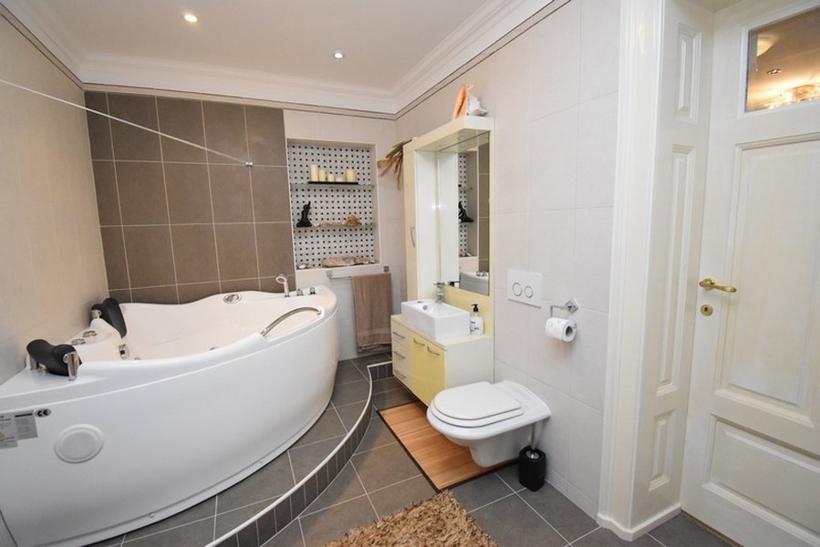 Salle de bains avec baignoire d'angle et WC