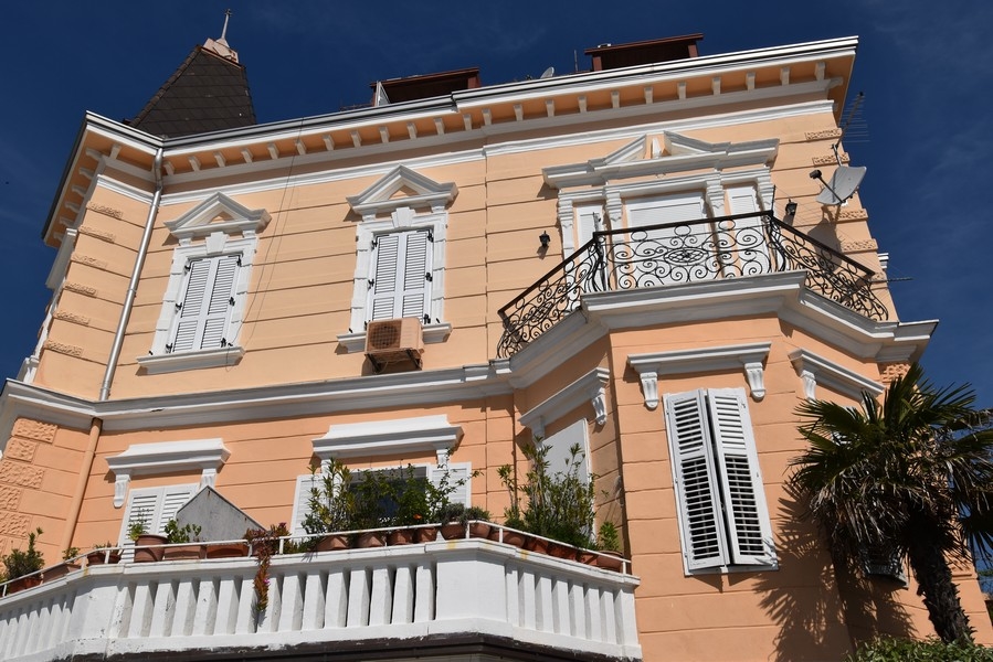 Immeuble ancien abricot avec balcon en fer forgé
