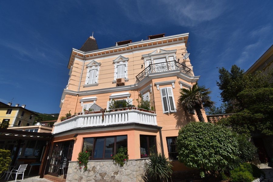 Immeuble ancien abricot avec bow-window et balcon en fer forgé