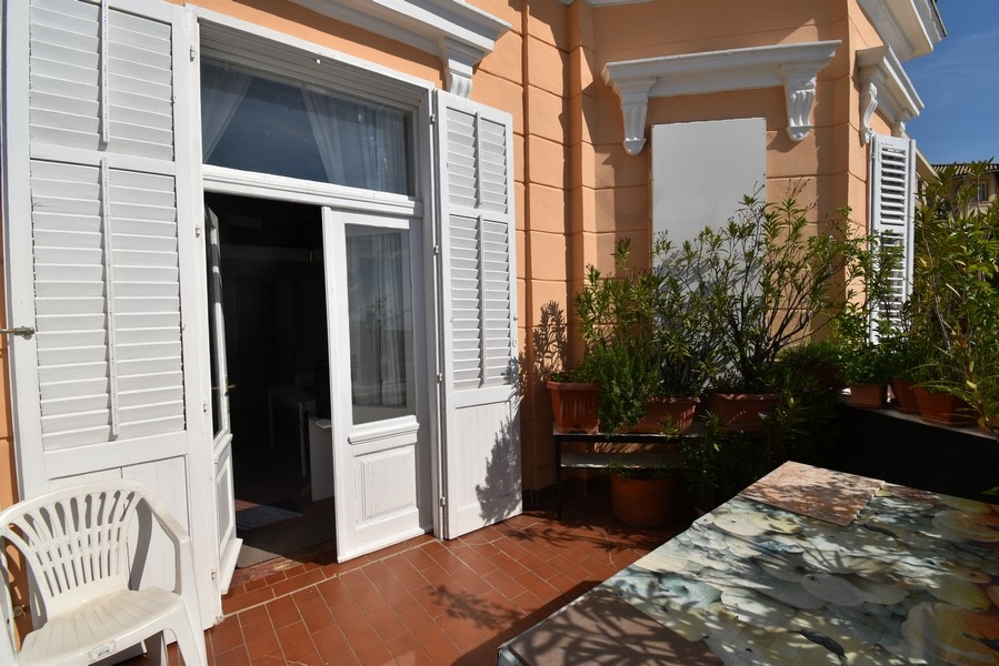 Porte de terrasse avec persiennes blanches sur la façade abricot