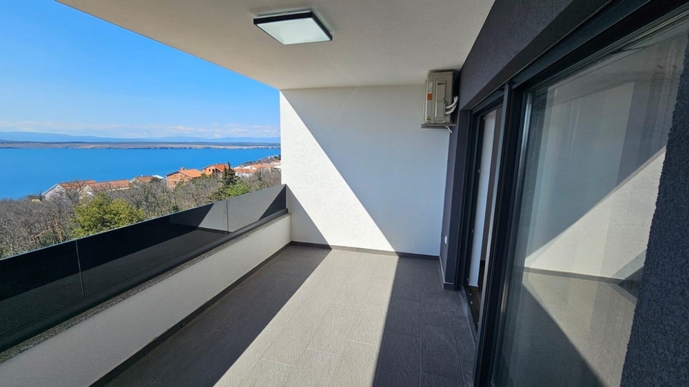 Balcon avec garde-corps en verre et vue sur le village jusqu'à l'eau