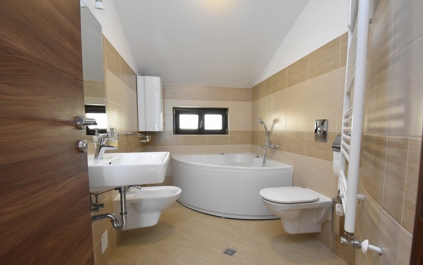 Salle de bains avec baignoire d'angle et WC