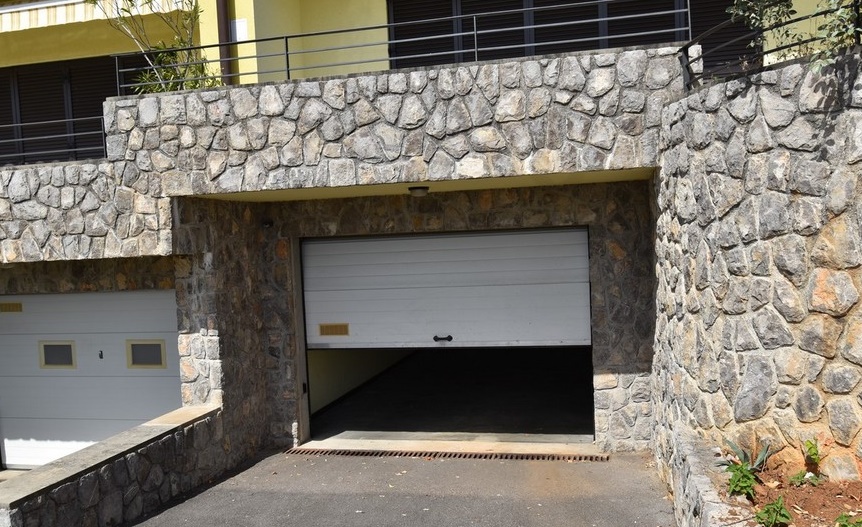Garage avec portail dans une façade en pierre naturelle