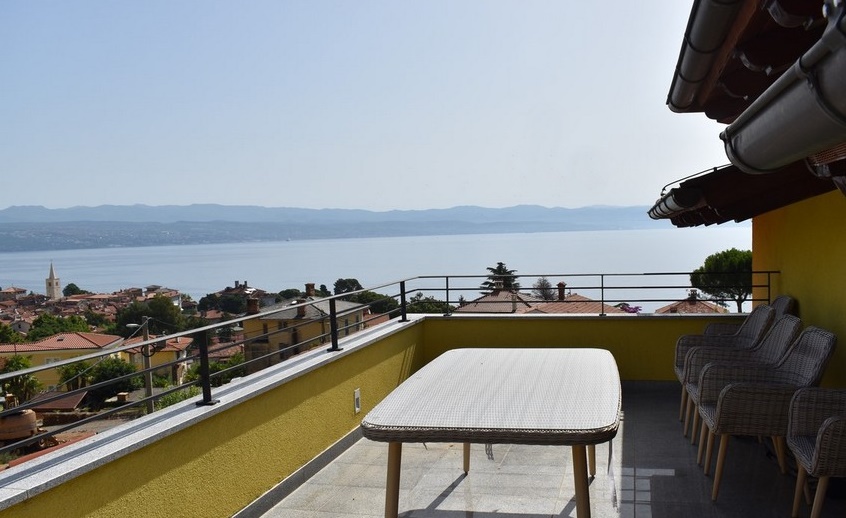 Toit-terrasse avec table et chaises au-dessus de la baie