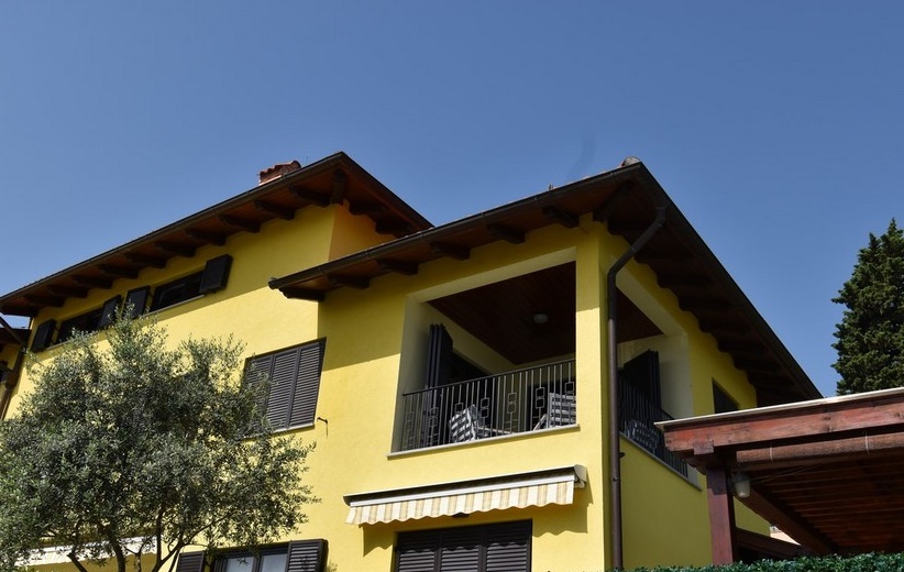 Maison jaune avec loggia et olivier devant