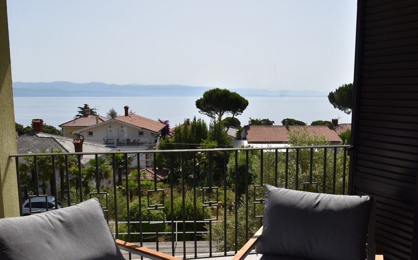 Balcon avec meubles rembourrés et vue au-dessus des pins sur la mer