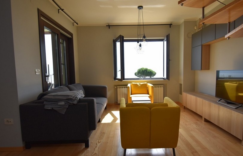 Salon avec canapé gris et fauteuils jaunes