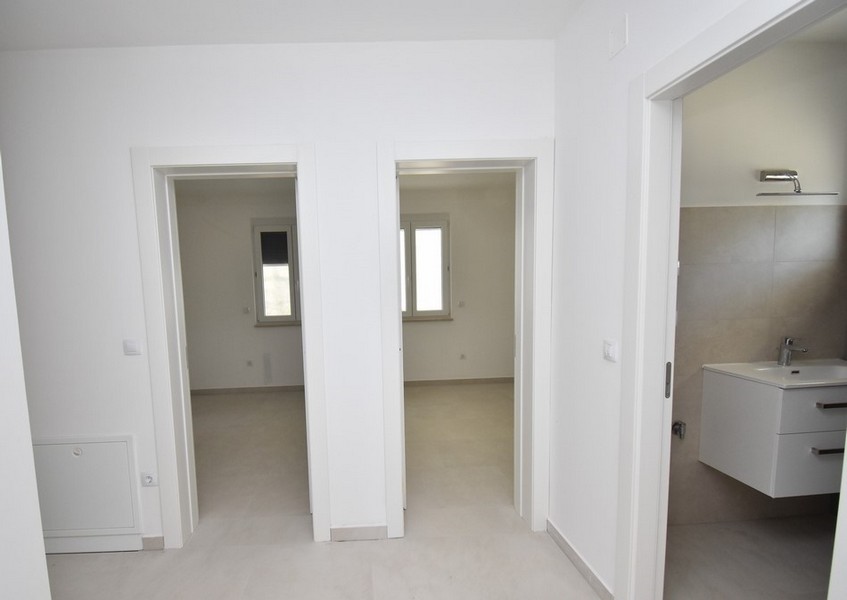 Entrée avec deux portes de pièces et vue sur la salle de bains