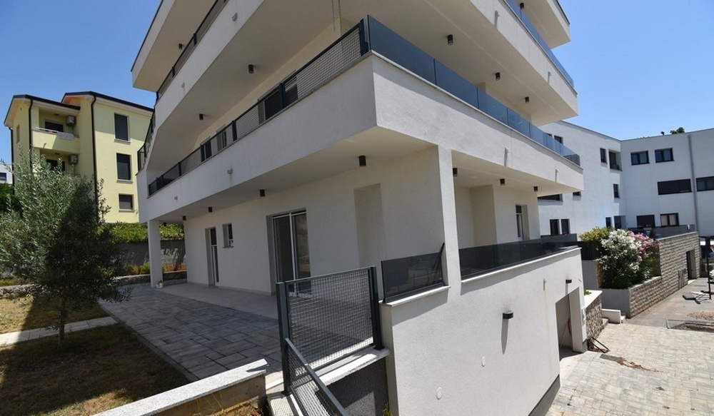 Immeuble d'habitation avec balcons et olivier dans le jardin de devant