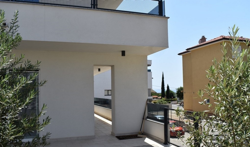 Passage sous le balcon entre des oliviers