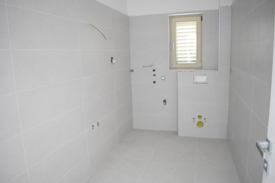 Salle de bains carrelée en gros œuvre avec raccords préparés