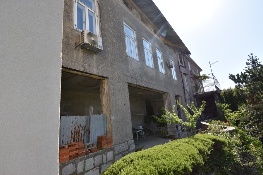 Côté de la maison non enduit avec ouvertures de garage ouvertes