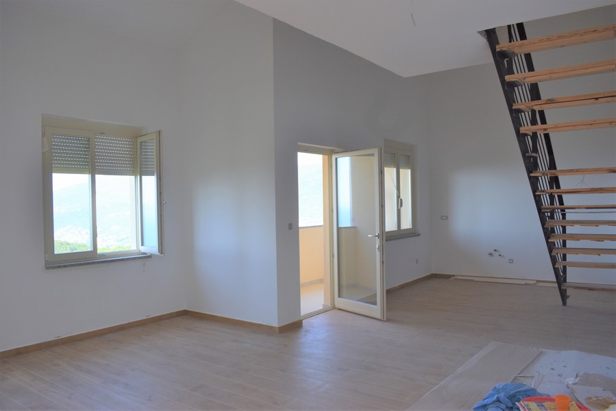 Pièce avec porte de balcon et escalier sous le toit en pente