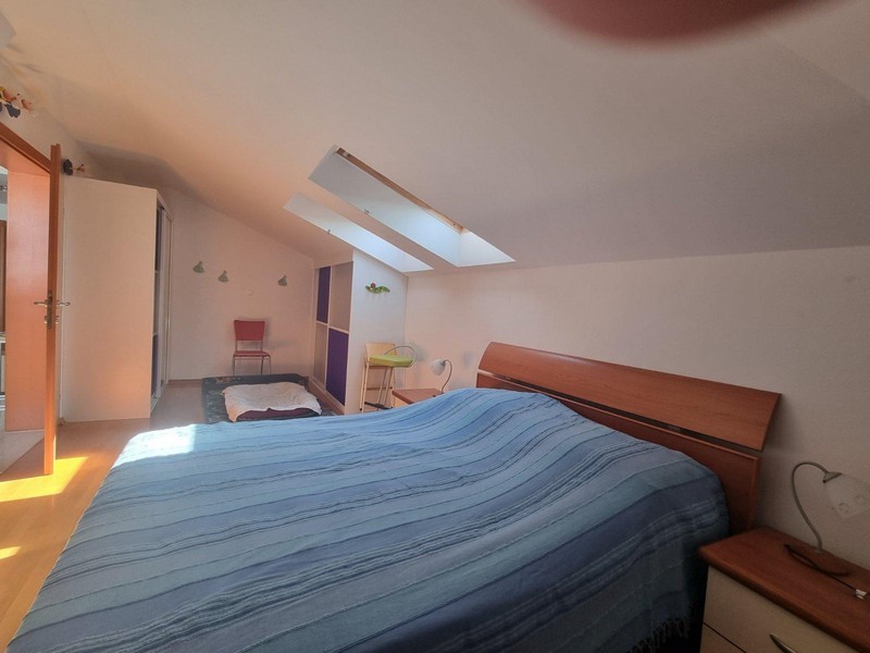 Chambre sous le toit en pente avec fenêtre de toit