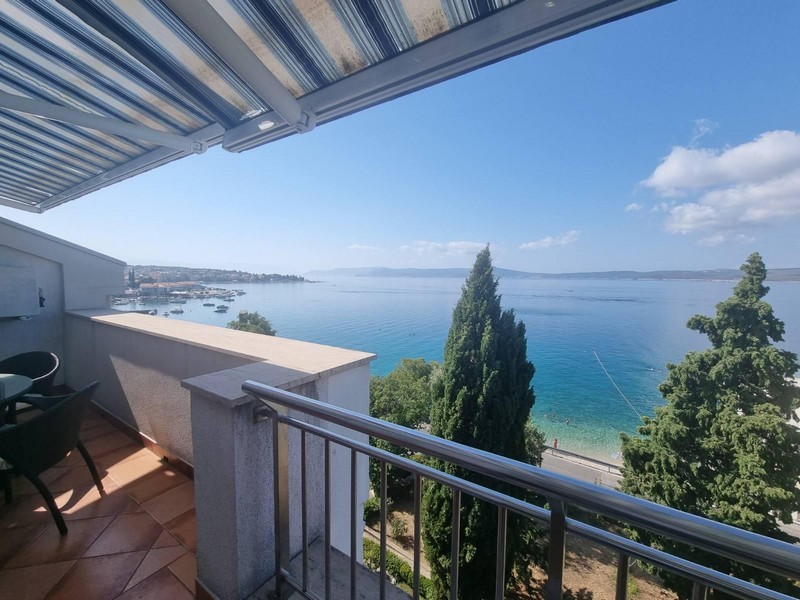 Balcon sous le store avec vue sur la baie et la plage
