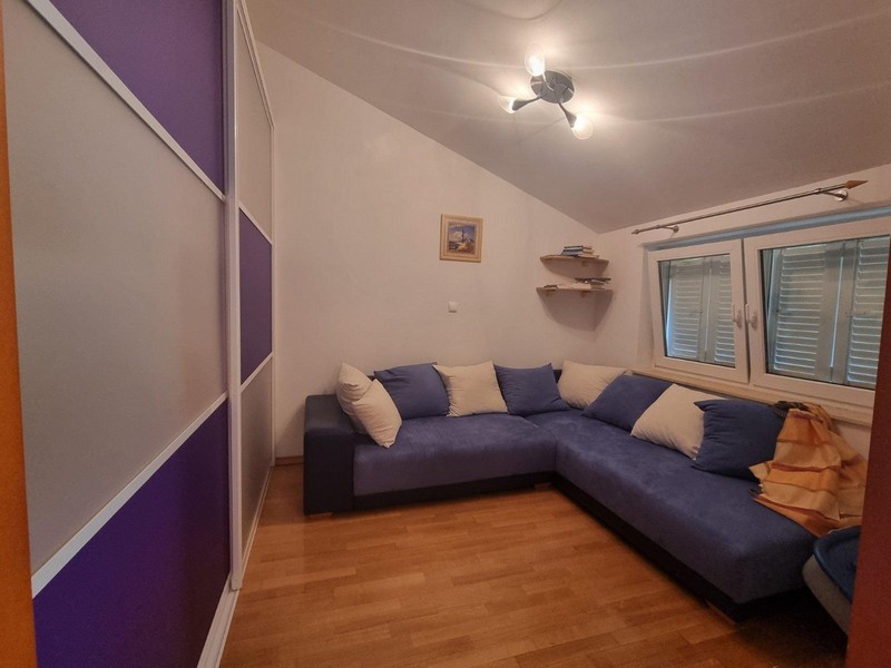 Pièce avec canapé d'angle bleu et armoire coulissante violette