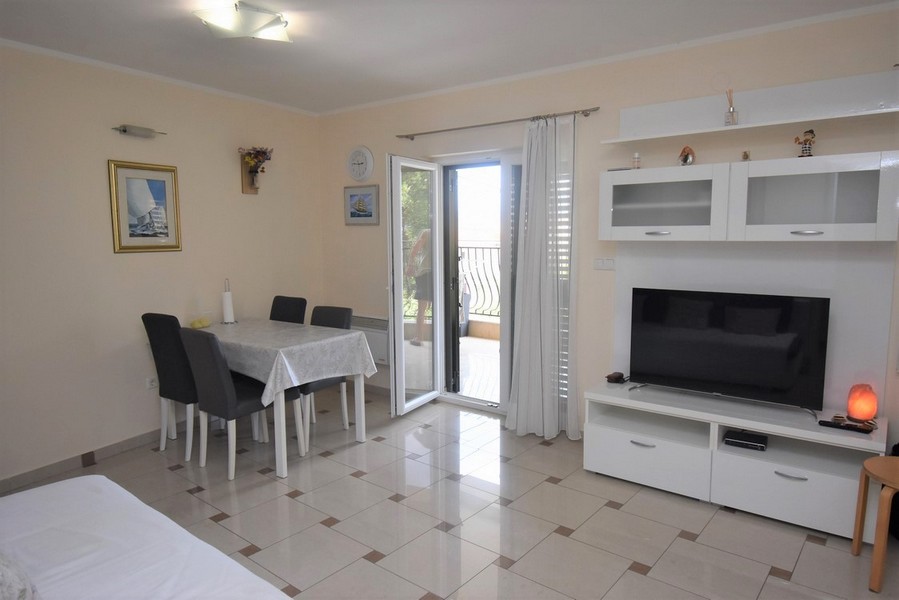 Séjour avec table, TV et porte de terrasse
