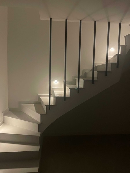 Escalier en colimaçon avec garde-corps à barreaux noirs dans la pénombre