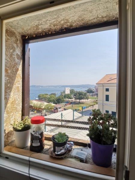 Vue mer par la fenêtre dans un appartement en ville à Rovinj