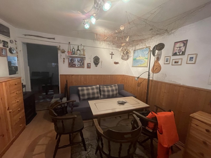 Pièce avec lambris en bois et tableaux au mur