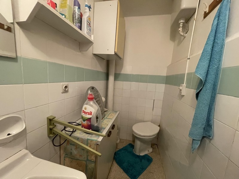 Petite salle de bains avec carrelage vert clair et étagère