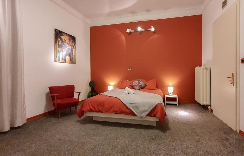 Chambre avec mur rouge et fauteuil