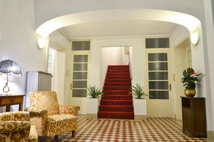 Hall d'entrée avec escalier et tapis rouge