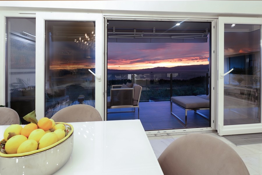 Vue par la porte de la terrasse sur le coucher du soleil