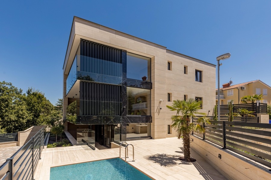 Appartement en rez-de-chaussée à Krk avec piscine et palmier devant la façade en pierre