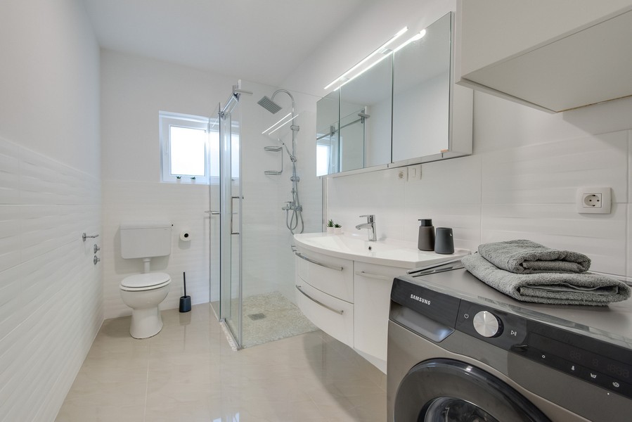 Salle de bains avec douche, WC et lave-linge