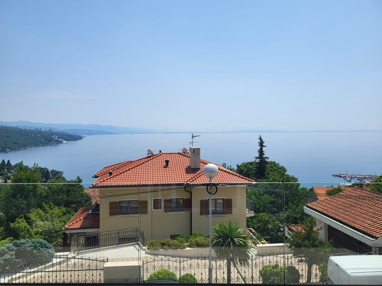 Maison voisine jaune avec toit de tuiles devant la pleine mer