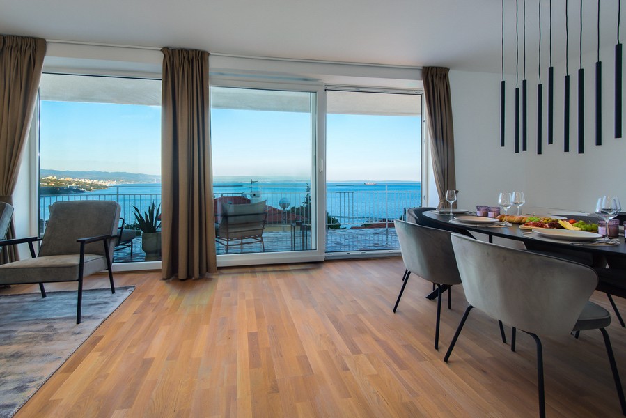 Séjour avec parquet et large façade vitrée donnant sur la baie
