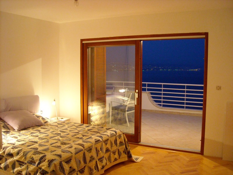 Chambre avec accès à la grande terrasse avec vue sur la ville et la mer.