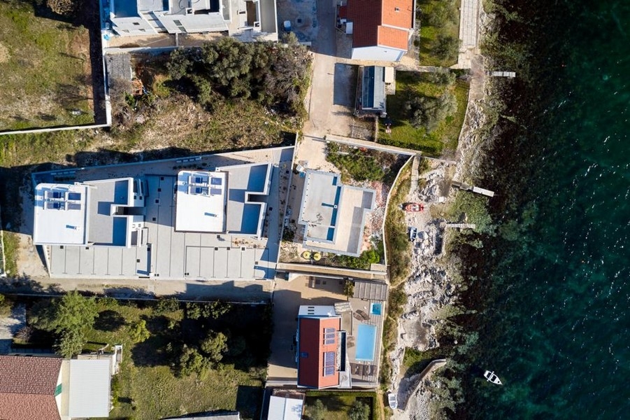Vue aérienne des constructions neuves avec côte rocheuse et plateforme de baignade