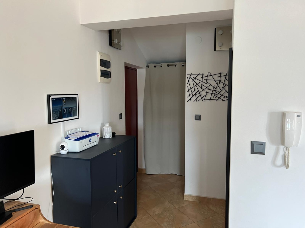 Couloir avec commode sombre et rideau devant la niche