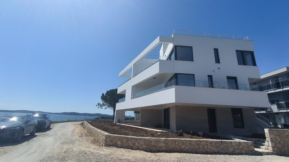 Immeuble neuf blanc avec balcons en saillie au bord de l'eau